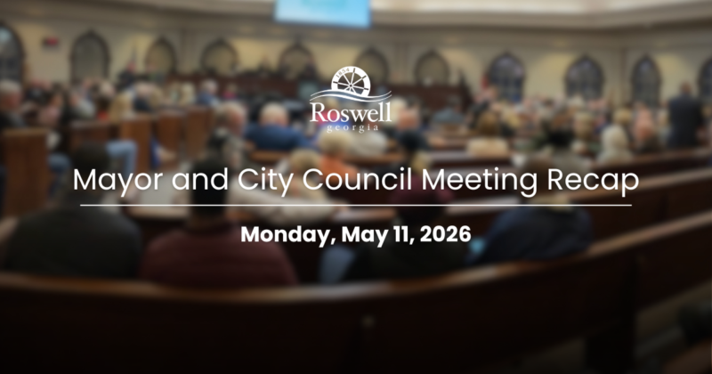 A photo of people in Roswell Council Chambers, with text overtop indicating the date.